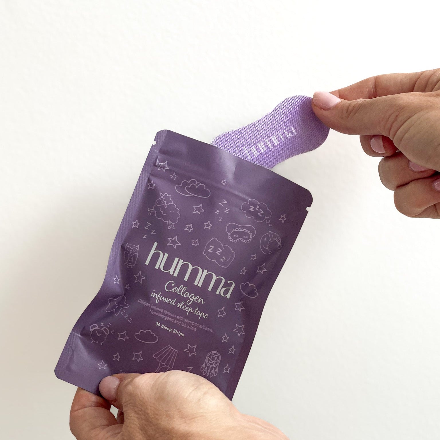 Person holding a purple 'humma' package against a white background