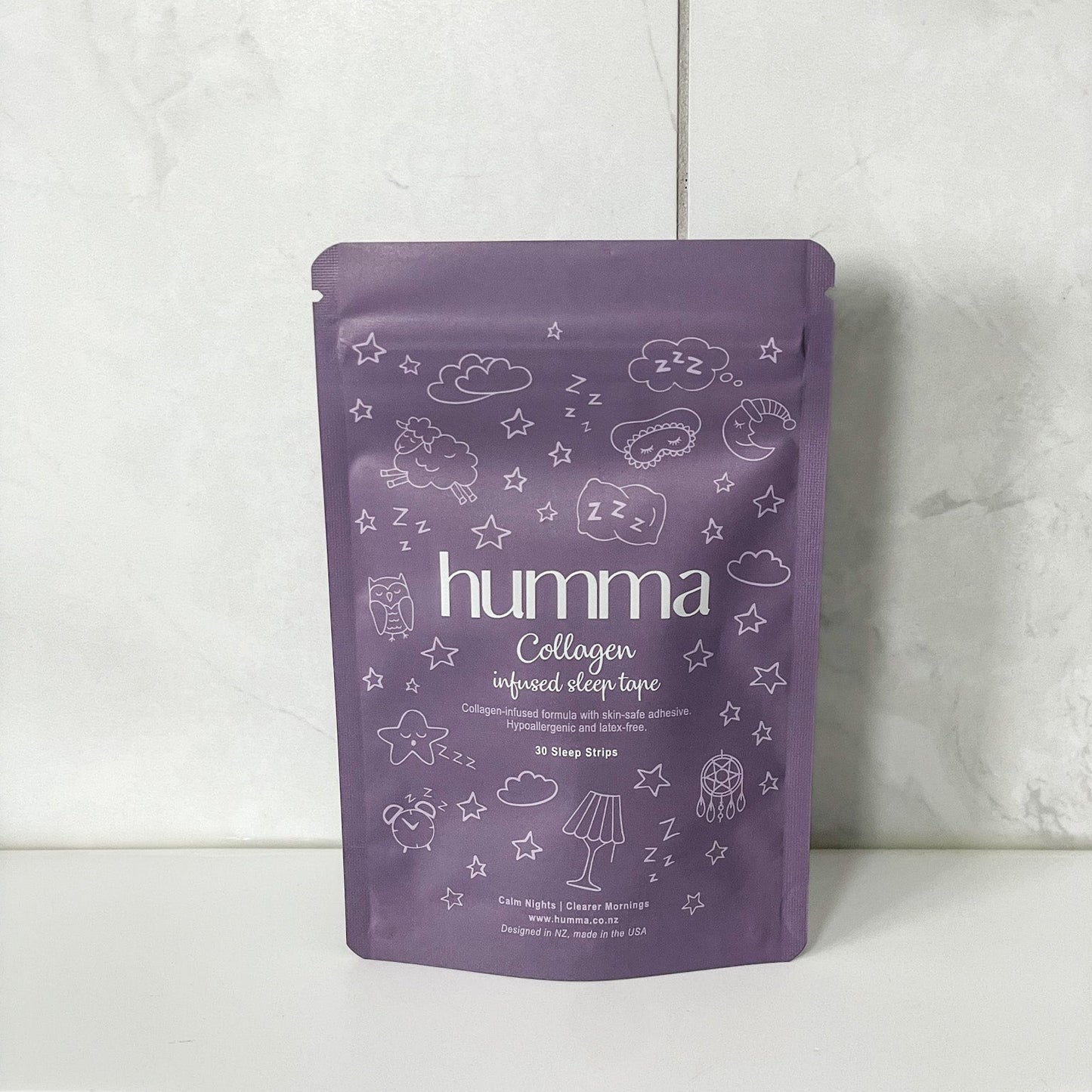 Purple package of humma Collagen on a white surface with a light gray tiled wall background